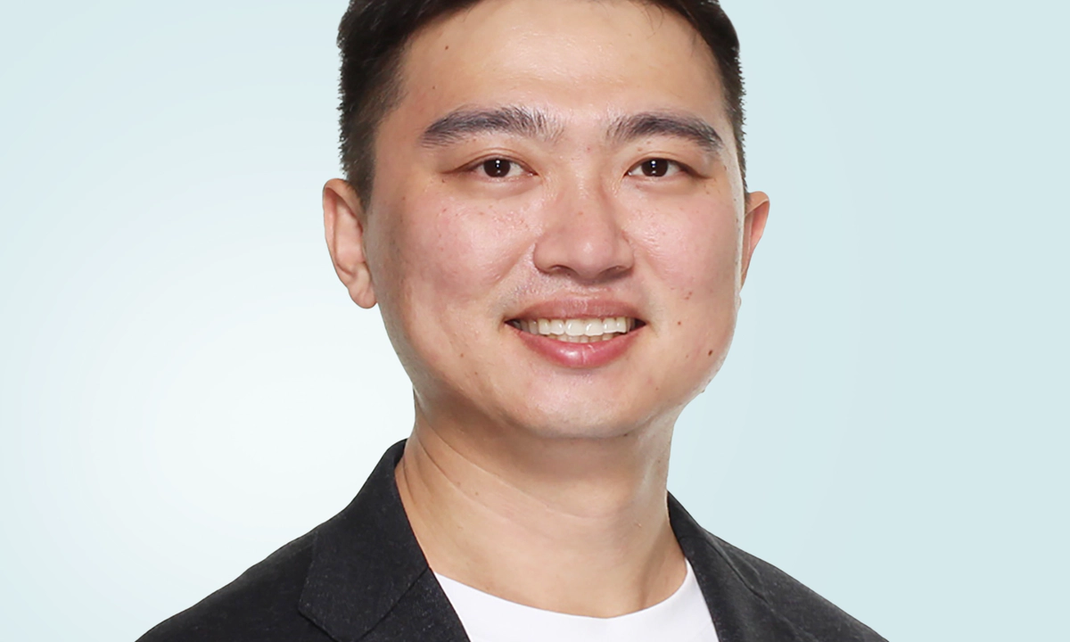 Jay Shen, an asian man with short black hair, and CEO of Transreport, in a grey suit, facing the camera.
