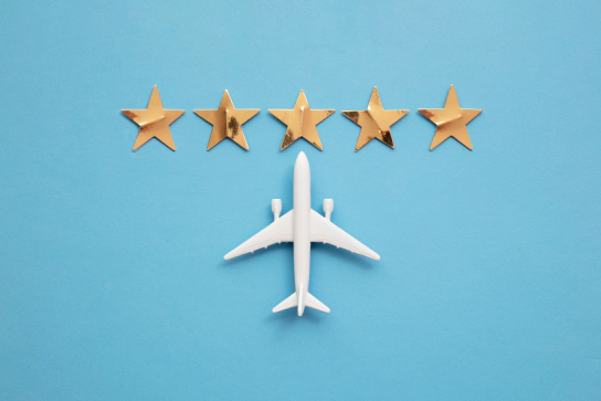 Accessibility Audits A birds' eye view of a model of a commercial passenger aeroplane, and five gold stars directly in front of the nose of the aeroplane.