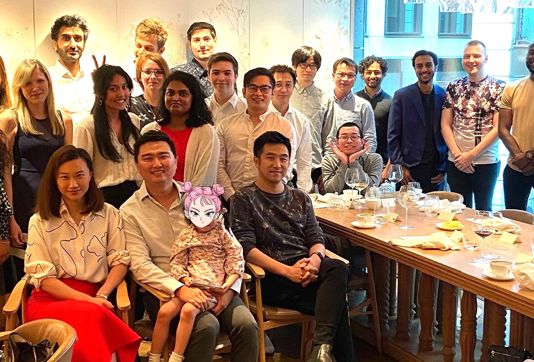 A group photo of some Transreport employees standing and sitting around a table.