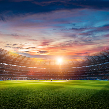A photo of a sports stadium with bright green grass, players on the pitch, and an open sky above. A photo of a sports stadium with bright green grass, players on the pitch, and an open sky above.