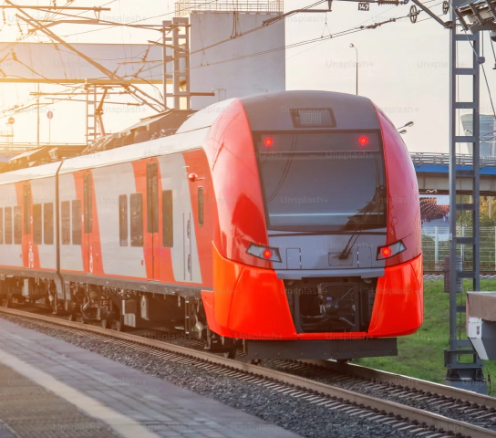 Photo of a red train beside a platform. Photo of a red train beside a platform.