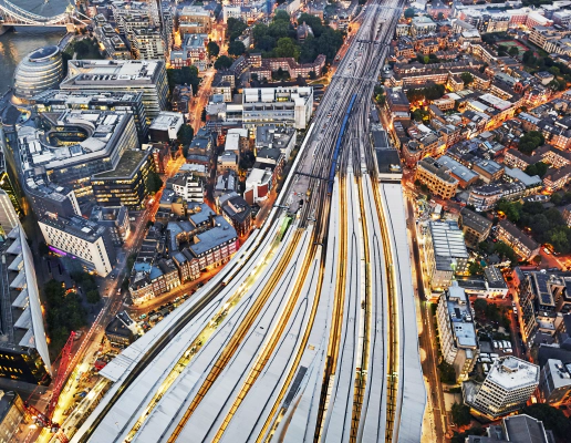 An aerial view of several trains on converging train tracks in a big city with skyscrapers. An aerial view of several trains on converging train tracks in a big city with skyscrapers.