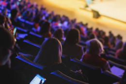 A photo of theatre-style seats in a venue packed with people.