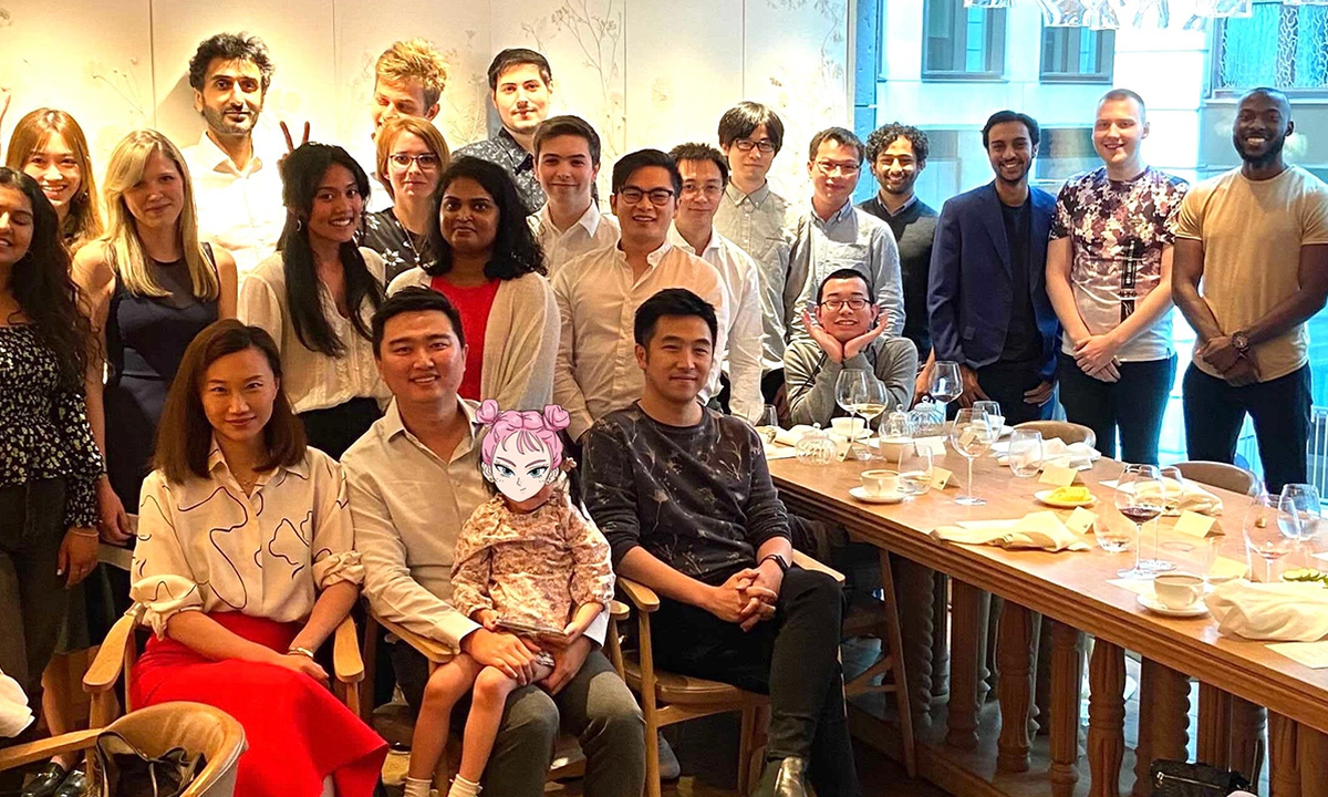 A group photo of some Transreport employees standing and sitting around a table.